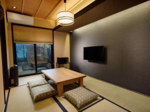 a living room with a wooden table and a tv at Kanade Fushimiinari-Inometei in Kyoto