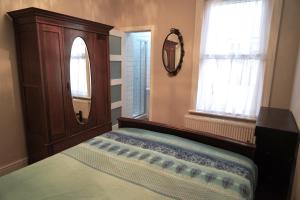 a bedroom with a bed and a mirror and a window at Tottenham Stadium double room in London