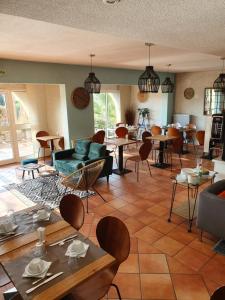 a living room with tables and chairs and a room with tables at Hôtel Athéna in Agde
