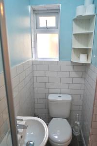 a bathroom with a toilet and a sink and a window at Tottenham Stadium double room in London