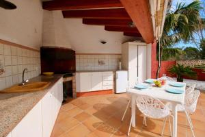 a kitchen with a white table and white chairs at Finca la Plana in Denia