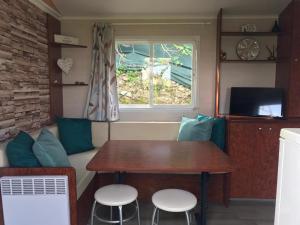 a small caravan with a table and chairs and a window at La casa azul in Xàtiva