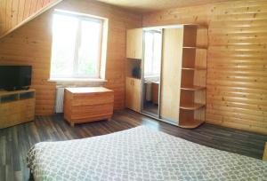 a bedroom with a bed and a dresser and a television at Садиба "В Поляні" in Polyana