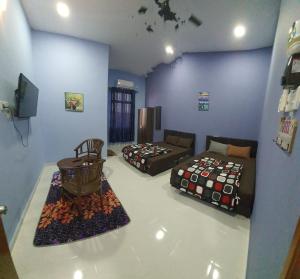 OYO 90252 Penginapan Wahee في كوالا ترغكانو: غرفة معيشة بها سريرين وأريكة