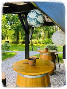 a wooden table under a tent with a blue canopy at Au Clair Des Landes in Castets