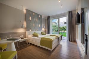 a bedroom with a bed and a table and a television at Hotel Villa Olivo Resort 3S in Bardolino