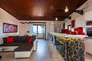 eine Küche und ein Wohnzimmer mit einem Sofa und einer Bar in der Unterkunft Villa Princess in Rethymno
