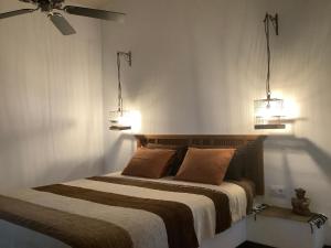 een slaapkamer met een bed met twee verlichting bij Kasbah Andaluz guest house in Chiclana de la Frontera +29 foto's