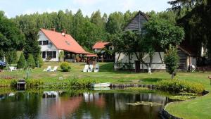 uma casa e um lago em frente a uma casa em Agroturystyka Dolinka em Szczecinek