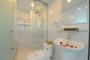 a bathroom with a shower and a sink and a toilet at Artisan Lakeview Hotel in Hanoi
