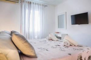 1 dormitorio con 1 cama con almohadas y TV de pantalla plana en THEA, en Vlachata