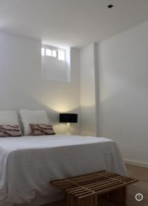 1 dormitorio con cama blanca y mesa en PLAZA CABILDO 4, en Sanlúcar de Barrameda