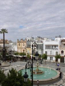 a city with a fountain in a plaza with buildings at PLAZA CABILDO 4 in Sanlúcar de Barrameda