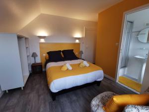 een slaapkamer met een groot bed met gele lakens en zwarte kussens bij TREAS GLAZ in Plouescat