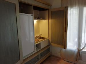 a kitchen with an open cabinet with a sink at Cavo Beach 1 in Cavo +6 photos