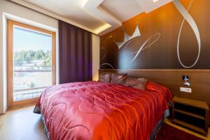 a bedroom with a red bed with a large window at Sissi Park in Lachtal