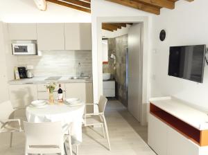 a kitchen and dining room with a white table and chairs at Appartamenti Ca' Gabri & Cici in Garda +25 photos