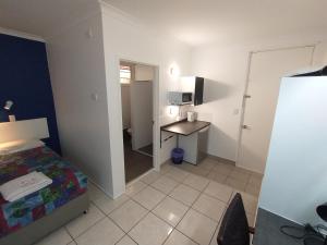1 dormitorio con 1 cama y escritorio en una habitación en Aspley Sunset Motel en Brisbane