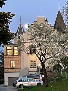 ein vor einem großen Gebäude geparkt in der Unterkunft Schloss Brunnegg in Kreuzlingen