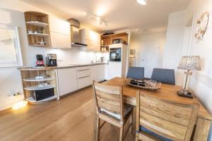 a kitchen and dining room with a wooden table and chairs at Meeresblick-Strandkoerbchen Haus 2 , WE 19 in Hohwacht