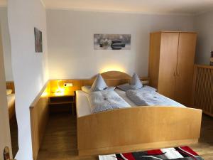um quarto com uma cama e uma cabeceira em madeira em Hotel u. Restaurant Goldener Greifen em Donauwörth