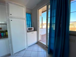 kuchnia z drzwiami otwierającymi się na balkon w obiekcie Perseo House Beach w mieście Palermo +5 zdjęć