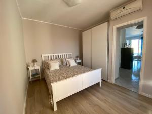 sypialnia z białym łóżkiem z poduszkami w obiekcie Perseo House Beach w mieście Palermo
