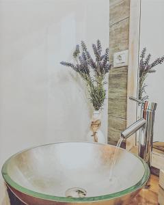 um lavatório com torneira numa casa de banho com flores em Il Ritrovo di Ulisse em Villa San Giovanni