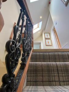 eine Wendeltreppe mit schwarzen Geländern und eine Treppe in der Unterkunft Clan Young Suite Apartment-LUXURY CENTRAL GETAWAY!! in Berwick-Upon-Tweed