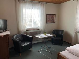 a room with two chairs and a table and a bed at Hotel Garni Siedlerstube in Nürtingen