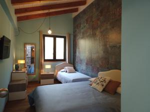 1 dormitorio con 2 camas y pared de ladrillo en Il Mandorlo, en Amantea