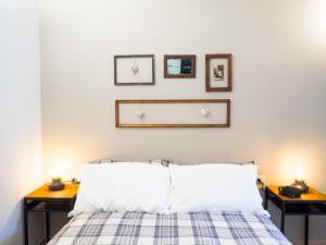 a bedroom with a bed with three pictures on the wall at Locanda Vecchio Cipresso in Chiaverano