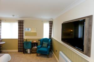a living room filled with furniture and a tv at Duck Bay Hotel & Restaurant in Balloch