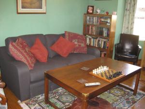 a living room with a couch and a chessboard on a table at Acorns Guest House in Combe Martin