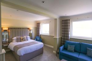 a bedroom with a bed and a blue couch at Duck Bay Hotel & Restaurant in Balloch