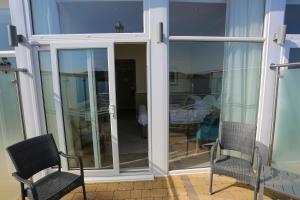 a sliding glass door with two chairs on a patio at Duck Bay Hotel & Restaurant in Balloch