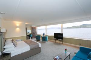 a hotel room with a bed and a large window at Duck Bay Hotel & Restaurant in Balloch