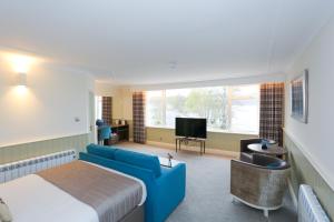 a hotel room with a bed and a couch and a tv at Duck Bay Hotel & Restaurant in Balloch +37 photos