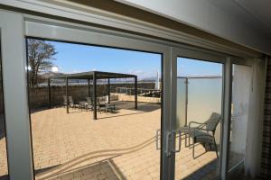 a sliding glass door of a patio with a table and chairs at Duck Bay Hotel & Restaurant in Balloch