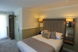 a hotel room with a bed and a television at Duck Bay Hotel & Restaurant in Balloch