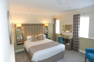a bedroom with a large bed and a blue chair at Duck Bay Hotel & Restaurant in Balloch
