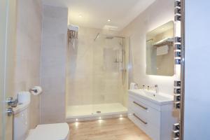a bathroom with a shower and a toilet and a sink at Duck Bay Hotel & Restaurant in Balloch