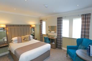 a hotel room with a bed and a blue chair at Duck Bay Hotel & Restaurant in Balloch