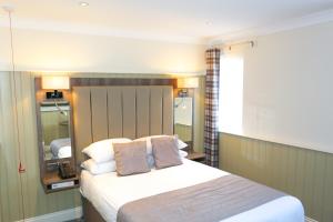 a bedroom with a bed with two pillows at Duck Bay Hotel & Restaurant in Balloch