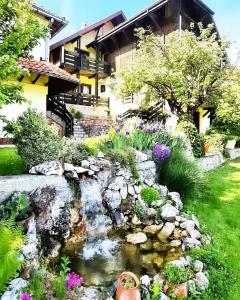 um jardim com um lago em frente a uma casa em Vila Djordjevic - Priroda vas okruzuje em Brus