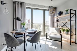 uma sala de jantar com uma mesa e cadeiras e uma janela em Old Town – OldNova by Welcome Apartment em Gdansk