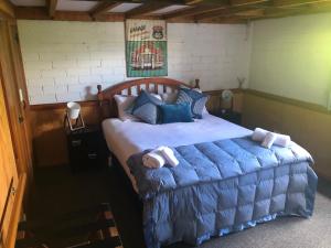 a bedroom with a large bed with blue sheets at The Workshops Clyde in Clyde