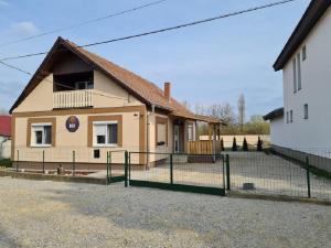 ein Haus mit einem Zaun davor in der Unterkunft Hócza House Poroszló in Poroszló