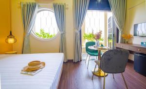 um quarto com uma cama com um chapéu e uma mesa em Sun City Hotel Da Nang em Da Nang
