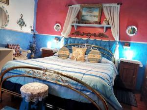 una camera con letto e pareti blu e rosse di Art B&B La Casa del Pittore a Revine Lago